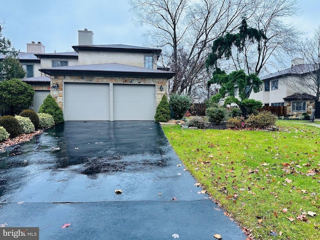 view of property exterior with aphalt driveway, stone siding, a lawn, and a chimney