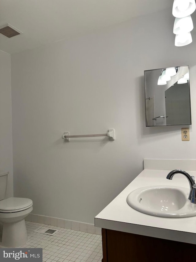 bathroom with toilet, vanity, visible vents, and tile patterned floors