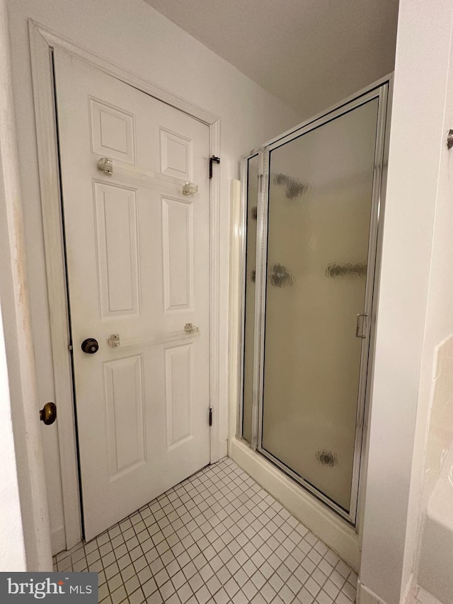 bathroom with a shower stall and tile patterned flooring