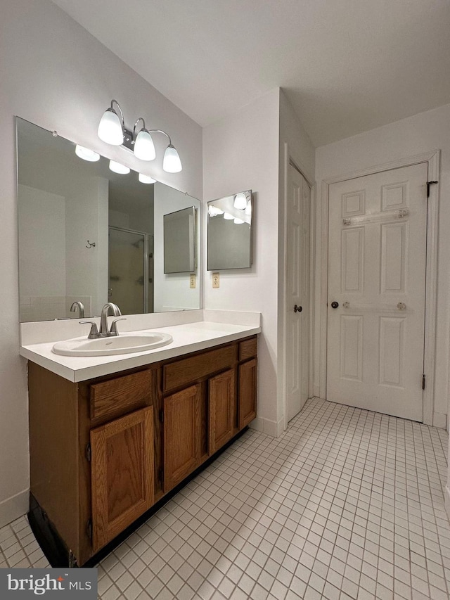 bathroom with a stall shower, tile patterned floors, and vanity