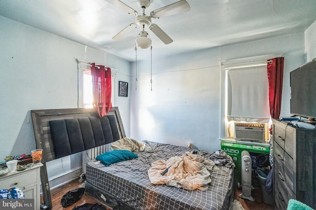 bedroom with cooling unit, ceiling fan, and dark hardwood / wood-style floors