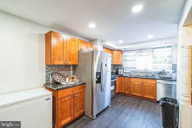 kitchen with sink, decorative backsplash, dark wood-type flooring, and stainless steel appliances