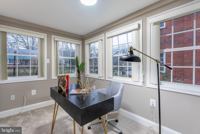 carpeted office space featuring baseboards