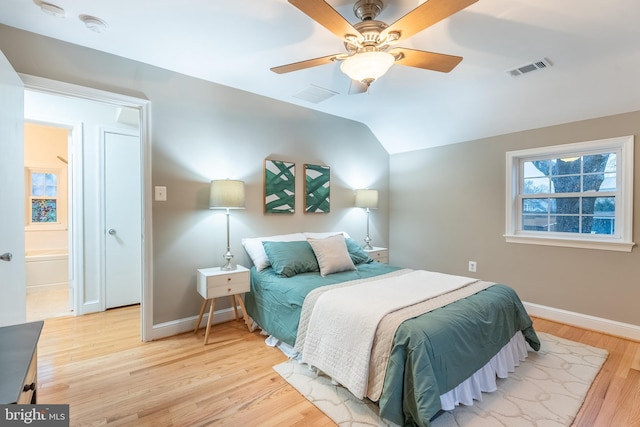 bedroom featuring lofted ceiling, light wood finished floors, baseboards, and visible vents