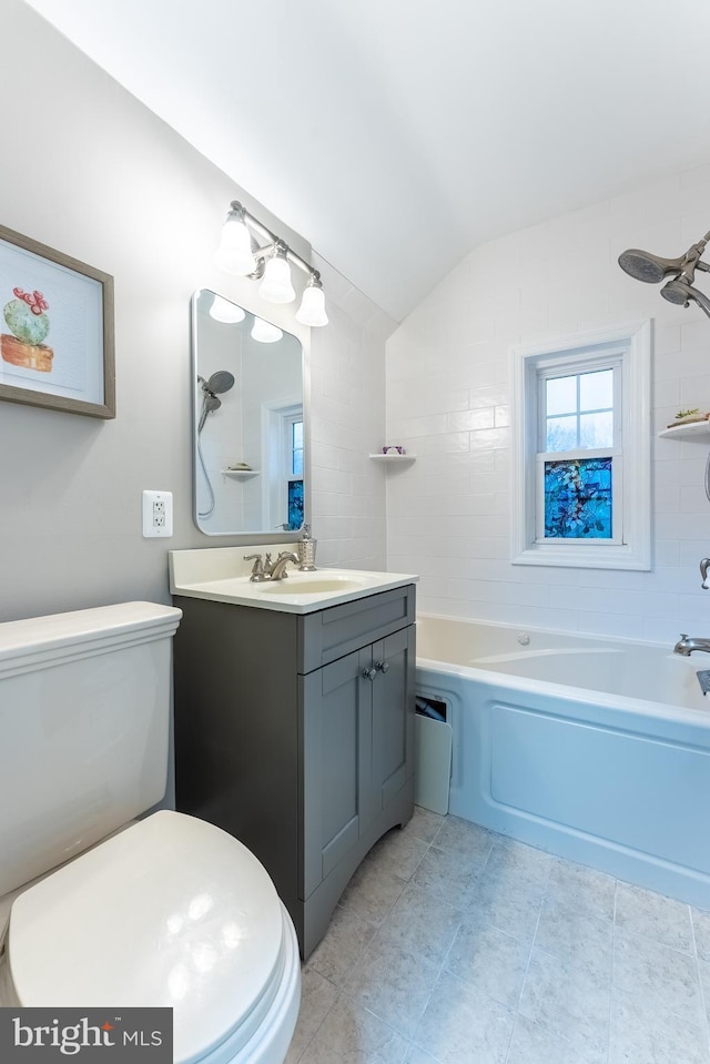 bathroom featuring lofted ceiling, shower / tub combination, tile patterned flooring, toilet, and vanity