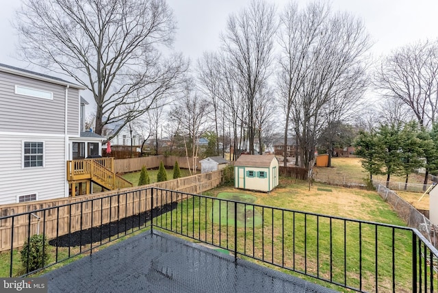 view of yard featuring a storage shed, a fenced backyard, stairway, and an outdoor structure