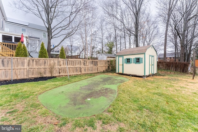 view of yard featuring a fenced backyard, an outdoor structure, and a shed