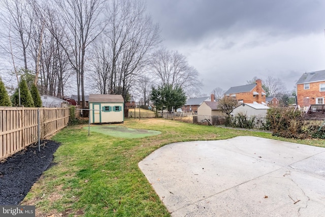 view of yard featuring an outbuilding, a storage unit, a fenced backyard, and a residential view