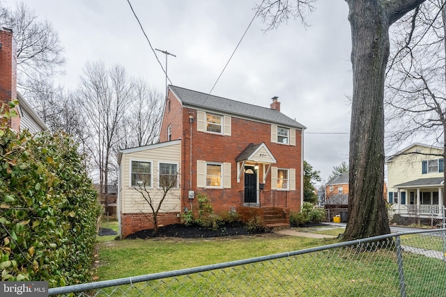 view of front of house featuring a front yard, brick siding, fence, and a chimney