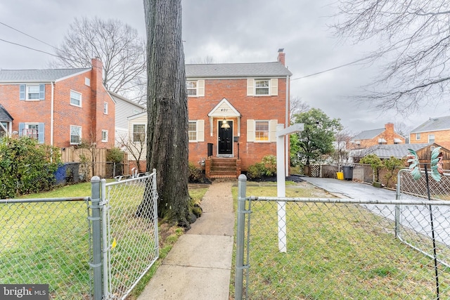 view of front of home with entry steps, a fenced front yard, brick siding, a front lawn, and a chimney