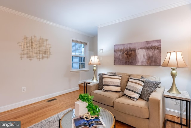 living room with visible vents, crown molding, baseboards, and wood finished floors