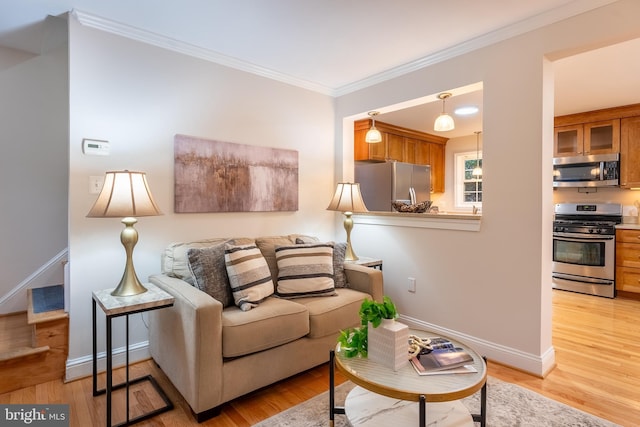 living area with ornamental molding, light wood-type flooring, baseboards, and stairs