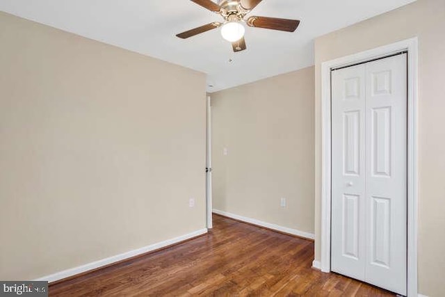 unfurnished bedroom featuring ceiling fan, dark hardwood / wood-style floors, and a closet