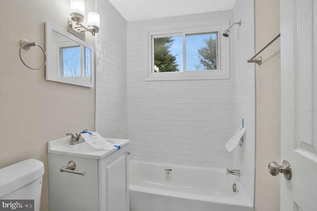 bathroom featuring tiled shower / bath and toilet