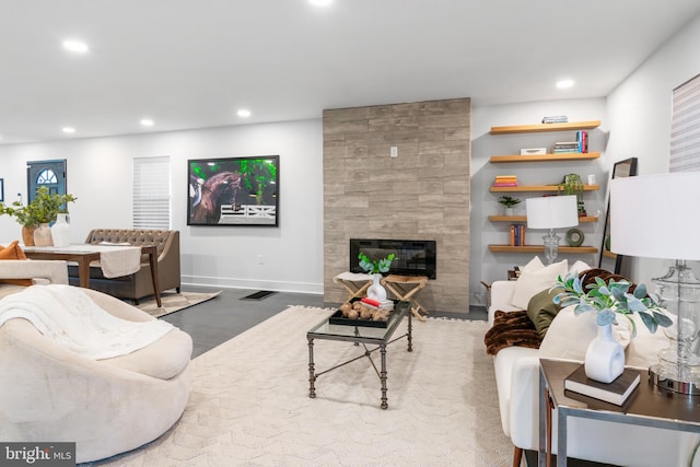 living room with a fireplace and wood-type flooring