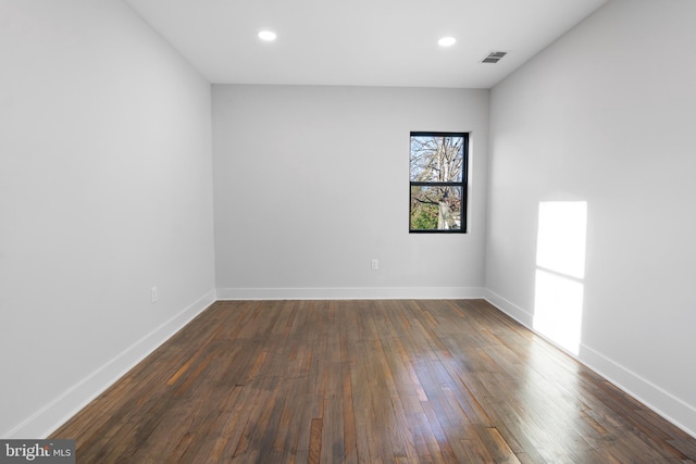 empty room with dark hardwood / wood-style flooring