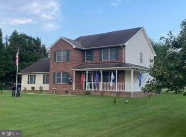 view of front of property with a porch and a front yard