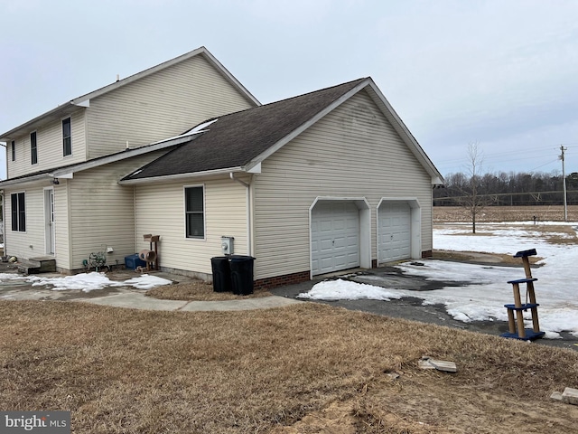 view of snowy exterior featuring a garage