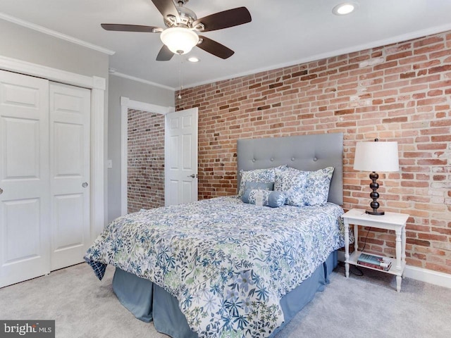 carpeted bedroom featuring ornamental molding, a closet, ceiling fan, and brick wall