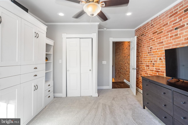 unfurnished bedroom featuring light colored carpet, ornamental molding, ceiling fan, and brick wall