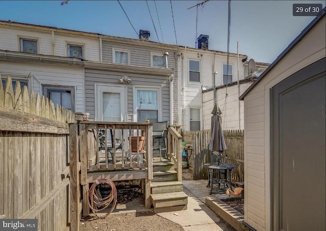 back of property with fence private yard and a wooden deck