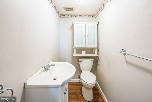 bathroom with wood-type flooring, vanity, and toilet