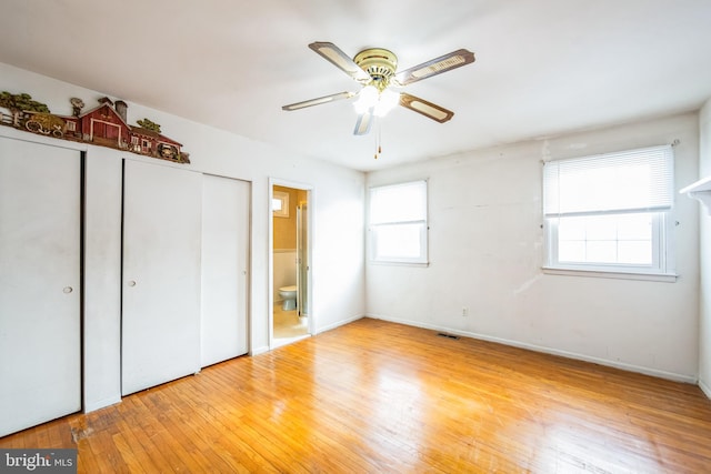 unfurnished bedroom with ensuite bathroom and light hardwood / wood-style floors