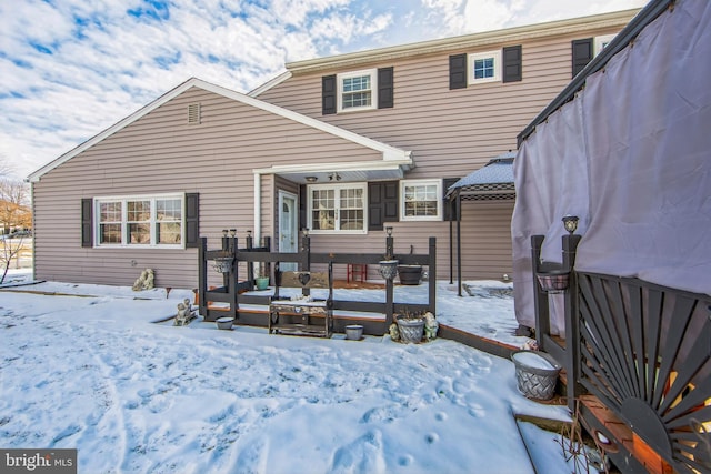 view of snow covered rear of property