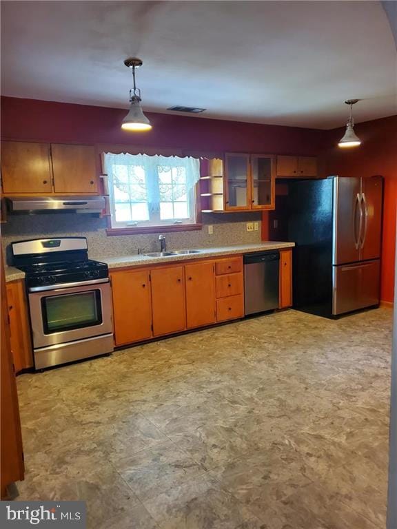 kitchen featuring appliances with stainless steel finishes, sink, and decorative light fixtures