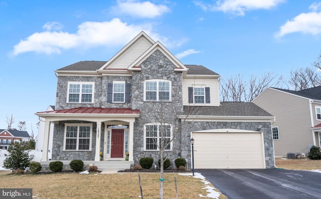 view of front of home with central AC, a garage, and a front yard