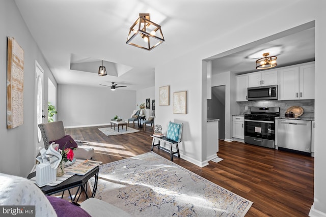 living room with ceiling fan and dark hardwood / wood-style floors