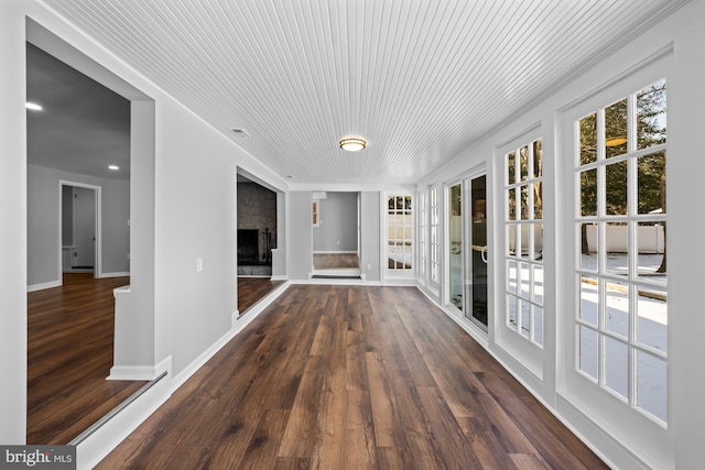 unfurnished sunroom with a large fireplace