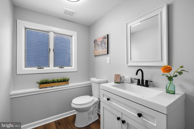 bathroom with vanity, wood-type flooring, and toilet