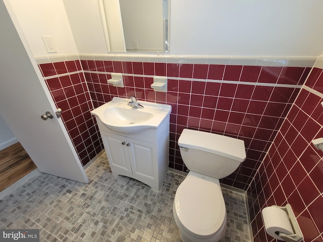 bathroom with tile patterned flooring, vanity, tile walls, and toilet