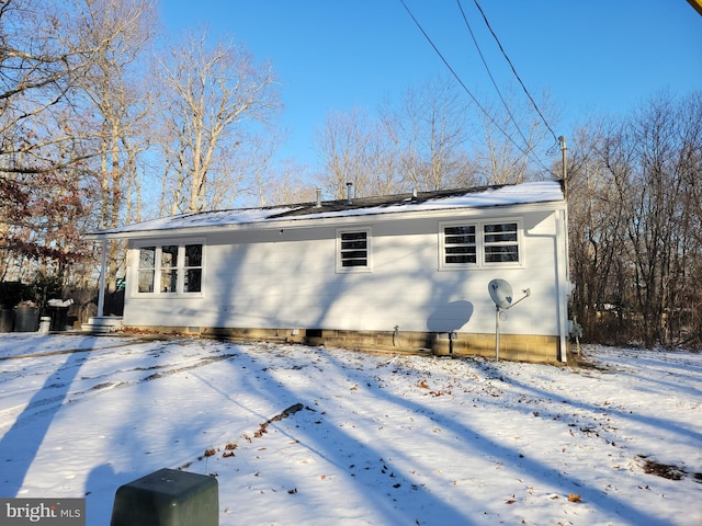 view of snow covered back of property