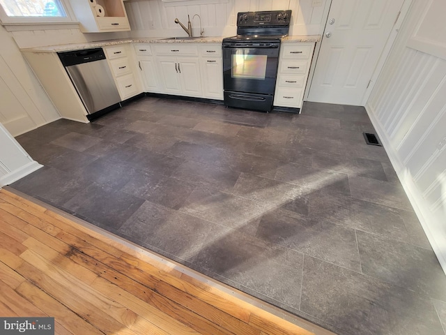 kitchen featuring black electric range oven, stainless steel dishwasher, sink, and white cabinets