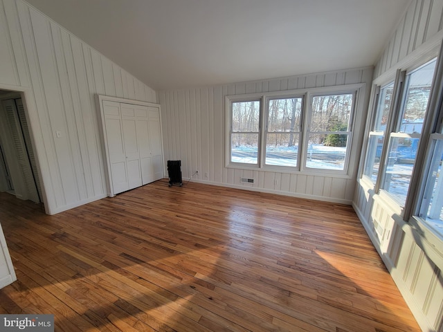 unfurnished bedroom with vaulted ceiling and light hardwood / wood-style floors