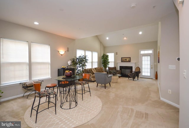 dining area featuring light colored carpet and vaulted ceiling