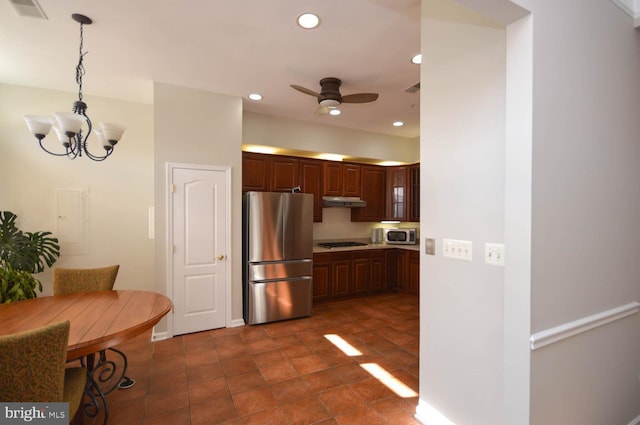 kitchen with hanging light fixtures, ceiling fan with notable chandelier, and stainless steel appliances