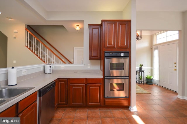 kitchen with appliances with stainless steel finishes, tile patterned flooring, and sink