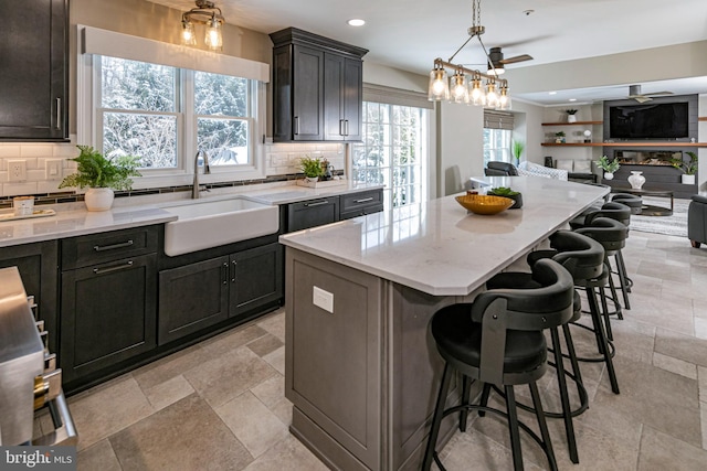 kitchen with tasteful backsplash, a kitchen breakfast bar, a center island, and sink