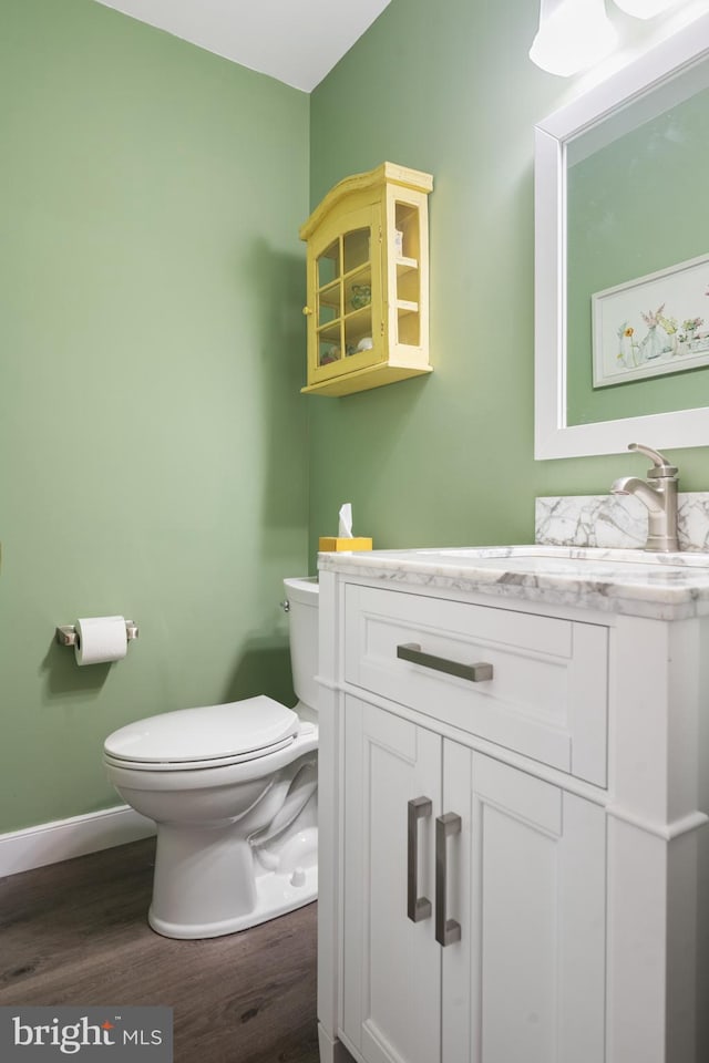 bathroom featuring vanity, wood-type flooring, and toilet