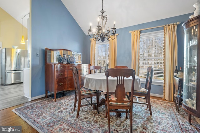 dining area featuring lofted ceiling, a notable chandelier, and hardwood / wood-style flooring