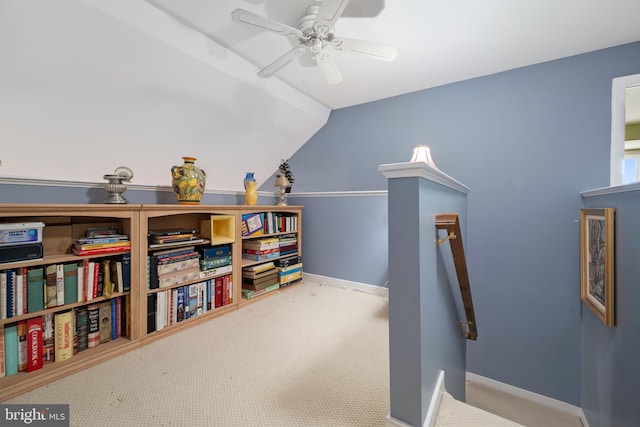 interior space with vaulted ceiling, carpet flooring, and ceiling fan