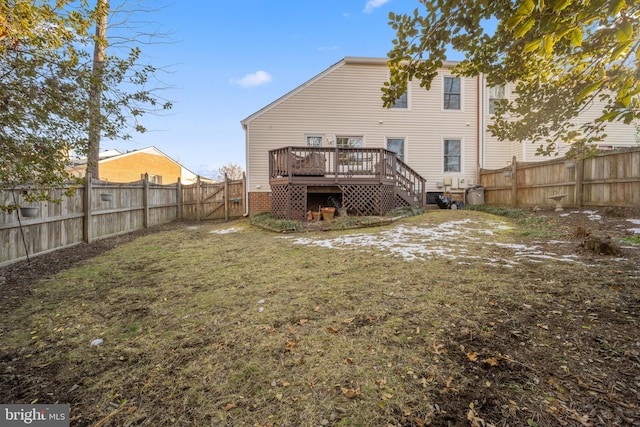 back of property with a wooden deck and a lawn