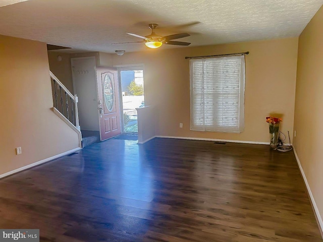 entrance foyer with dark hardwood / wood-style flooring, ceiling fan, and a textured ceiling