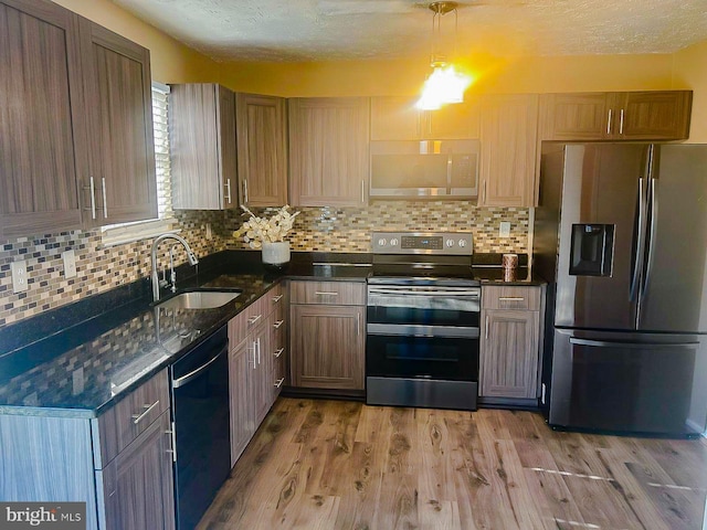 kitchen with hardwood / wood-style flooring, appliances with stainless steel finishes, sink, and backsplash