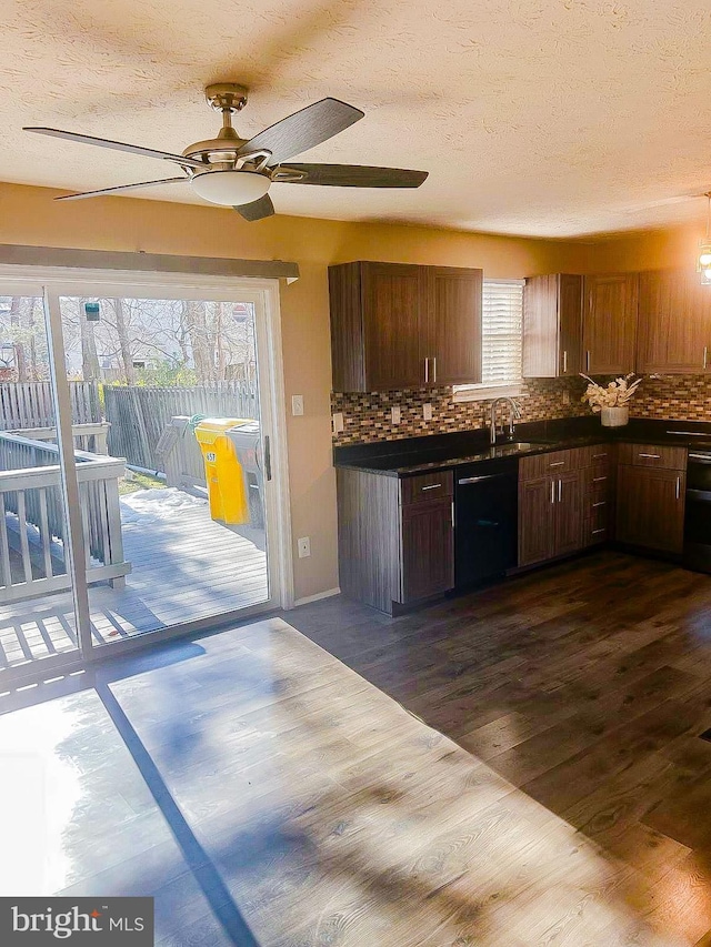 kitchen with dishwasher, a textured ceiling, dark hardwood / wood-style flooring, and decorative backsplash