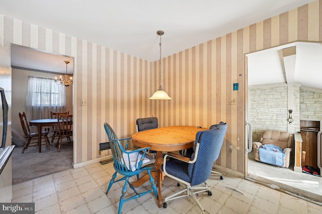 dining area with vaulted ceiling and a chandelier