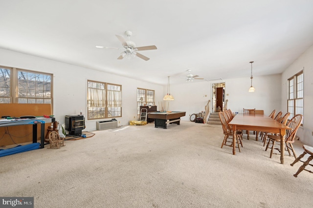 dining room featuring pool table, carpet, ceiling fan, and a wood stove